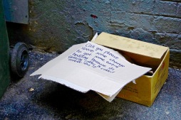 Discarded begging box down a side alley.